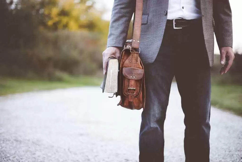 На фото учитель с портфелем и книгой.